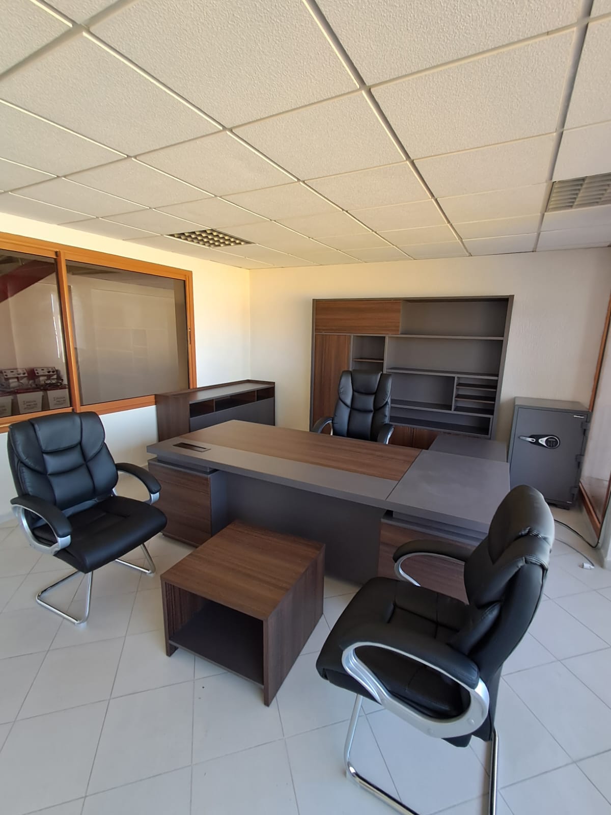 Bureau de direction bois et gris avec rangement mural assorti.